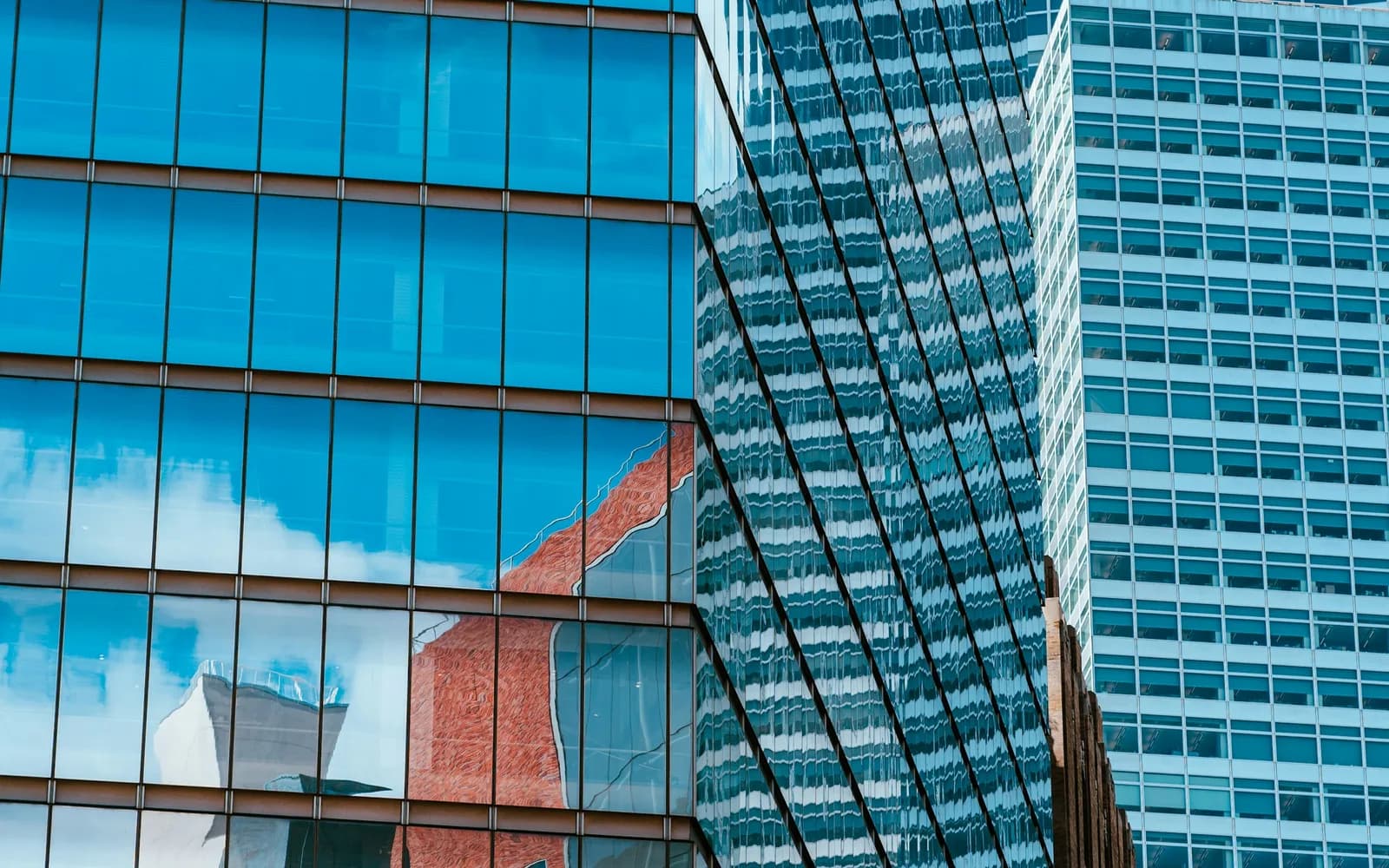 Reflections of a city street in blue-tinted glass